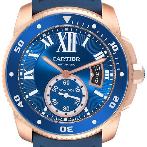 The image shows a front view of the Calibre de Cartier watch by Cartier, showcasing its blue dial, bezel, and partial case.