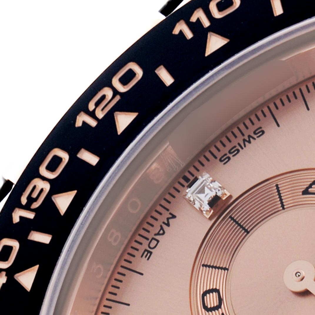 The image shows a close-up of the bezel and part of the dial of a Rolex Daytona 116515LN Men's Rose Gold Pink Dial 116515LN Men's Rose Gold Pink Dial, highlighting its tachymetric scale and diamond marker.