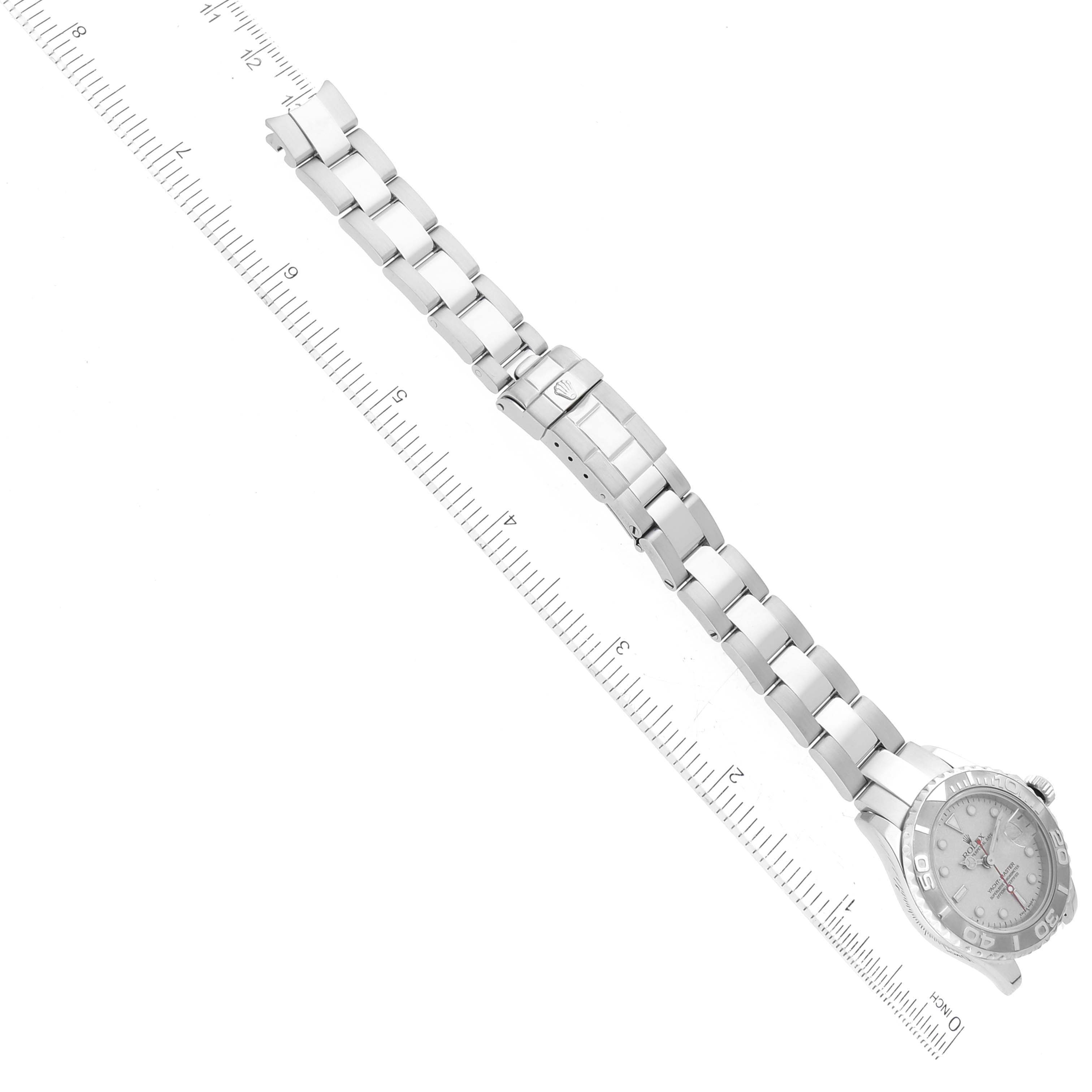 This image shows the Rolex Yacht-Master 169622 Women's Stainless Steel Silver Dial 169622 Women's Stainless Steel Silver Dial watch from an aerial view, focusing on the bracelet and clasp, with a ruler for scale.