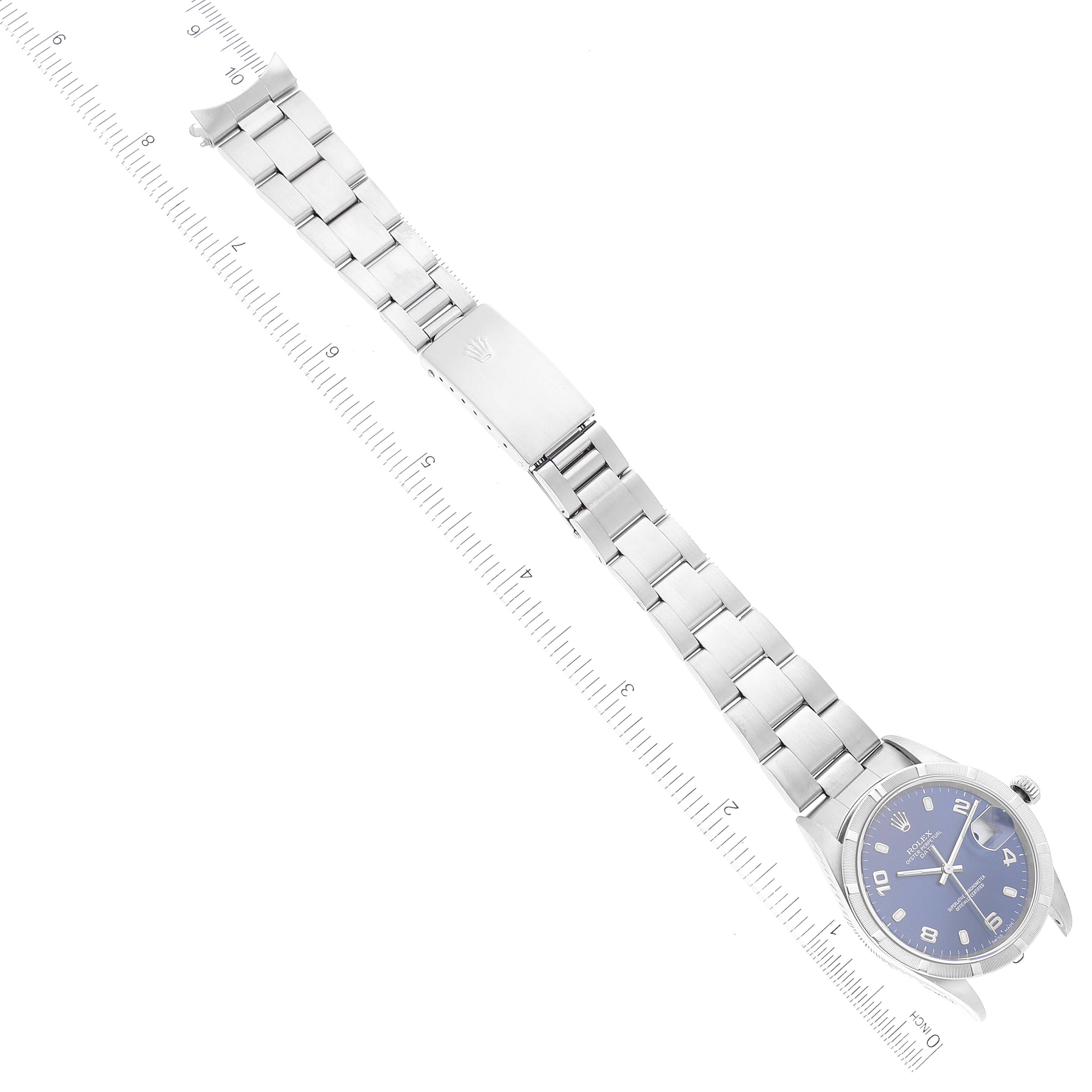 The image shows a Rolex Date 15210 Men's Stainless Steel Blue Dial 15210 Men's Stainless Steel Blue Dial model watch with a silver bracelet and a blue dial, displayed diagonally against a measuring ruler.
