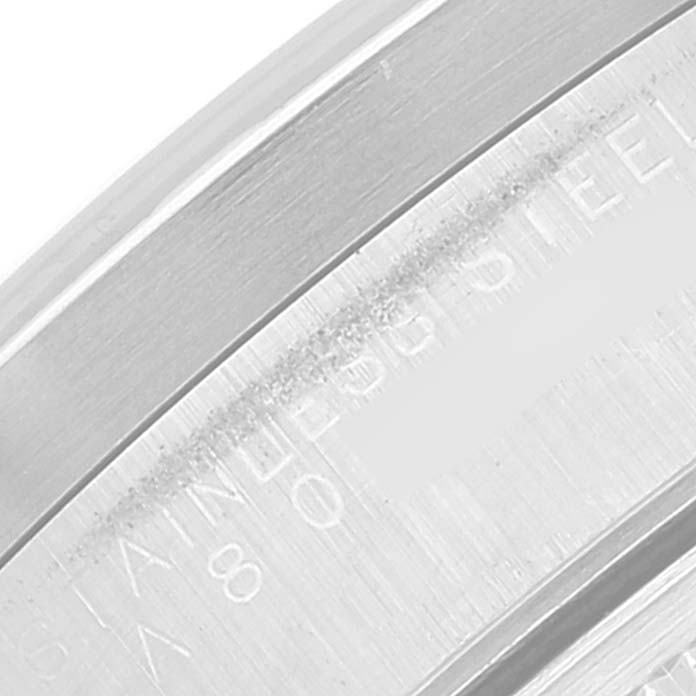 This close-up image of the Rolex Date 15210 Men's Stainless Steel Blue Dial 15210 Men's Stainless Steel Blue Dial model shows a portion of the case with engraved text indicating "STAINLESS STEEL."