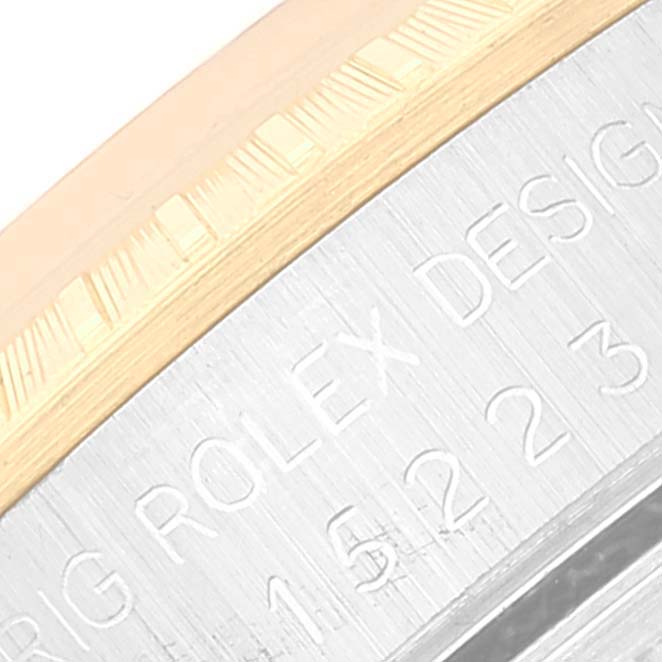 This close-up image of the Rolex Date 15223 Men's Steel and Gold (two tone) White Dial 15223 Men's Steel and Gold (two tone) White Dial model shows part of the bezel and engraved text on the case.