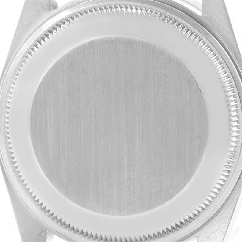 The image shows the back case of the Rolex Date 15210 Men's Stainless Steel Silver Dial 15210 Men's Stainless Steel Silver Dial model, viewed from an overhead angle and displays the textured edge and smooth center.