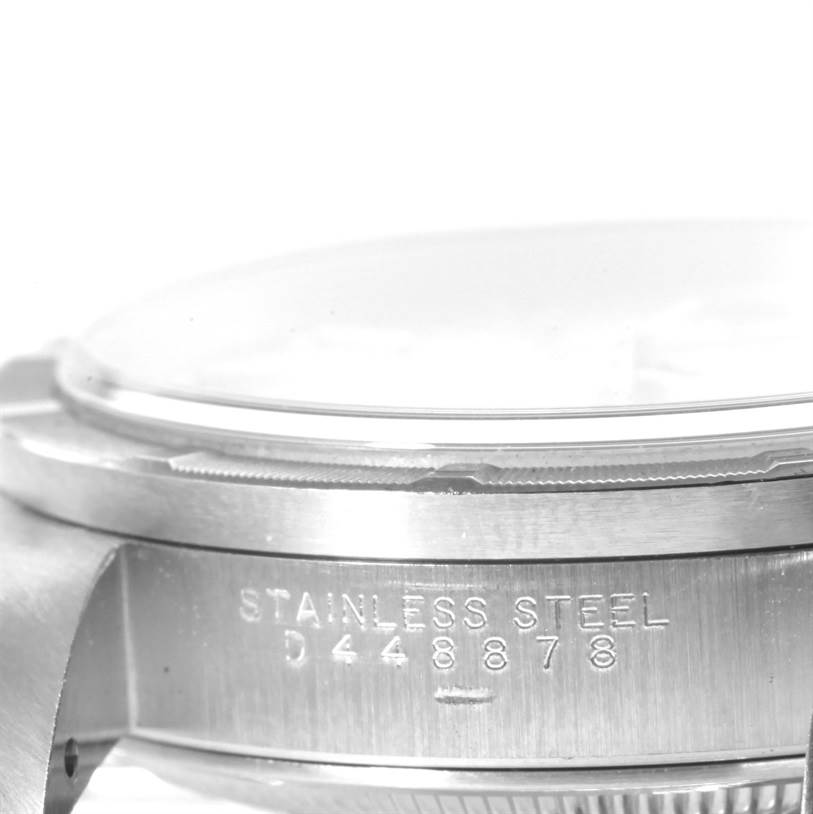 The image shows a close-up side view of a stainless steel case and crystal of a Rolex Date 15210 Men's Stainless Steel Silver Dial 15210 Men's Stainless Steel Silver Dial model watch, displaying its serial number.