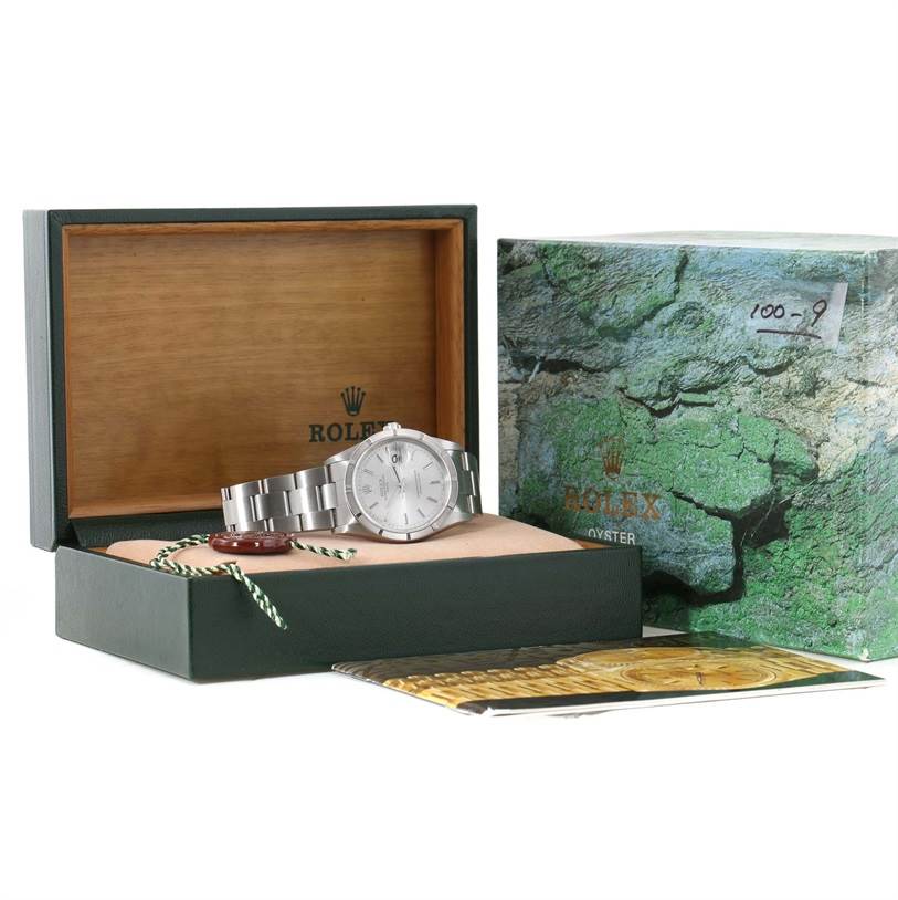 The image shows a Rolex Date 15210 Men's Stainless Steel Silver Dial 15210 Men's Stainless Steel Silver Dial watch in an open box, with its outer case, booklet, and accessories displayed.