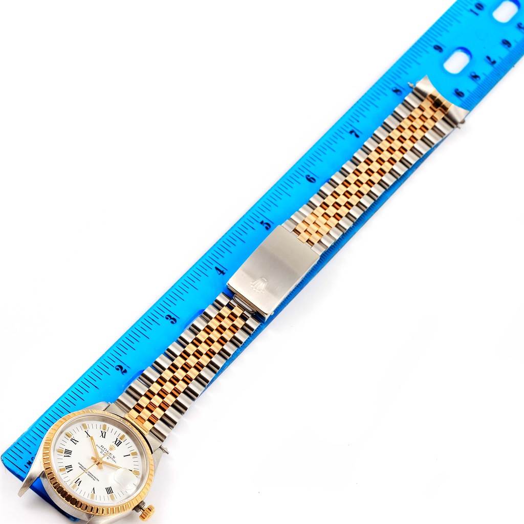 The image shows a Rolex Date 15223 Men's Steel and Gold (two tone) White Dial 15223 Men's Steel and Gold (two tone) White Dial model watch laid alongside a ruler, highlighting the watch's face, bezel, crown, and bracelet.