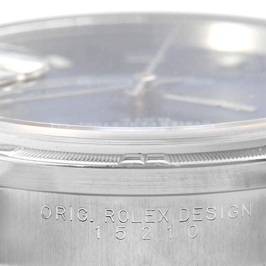 This close-up image of the Rolex Date 15210 Men's Stainless Steel Blue Dial 15210 Men's Stainless Steel Blue Dial model shows the bezel, crystal, and part of the engraved watch case with the design number 15210.