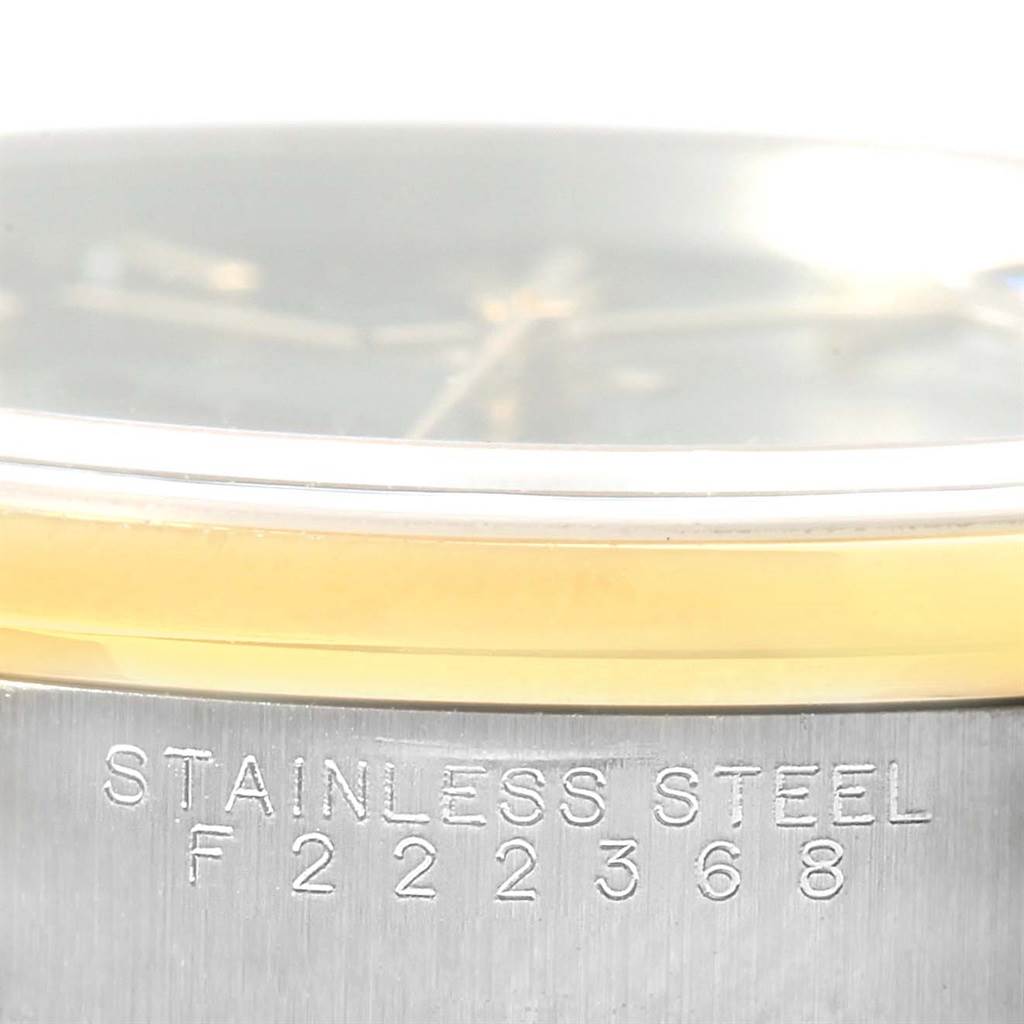 This image shows a close-up of the side of a Rolex Date 15203 Men's Steel and Gold (two tone) Black Dial 15203 Men's Steel and Gold (two tone) Black Dial watch, highlighting the stainless steel part with a serial number engraved.