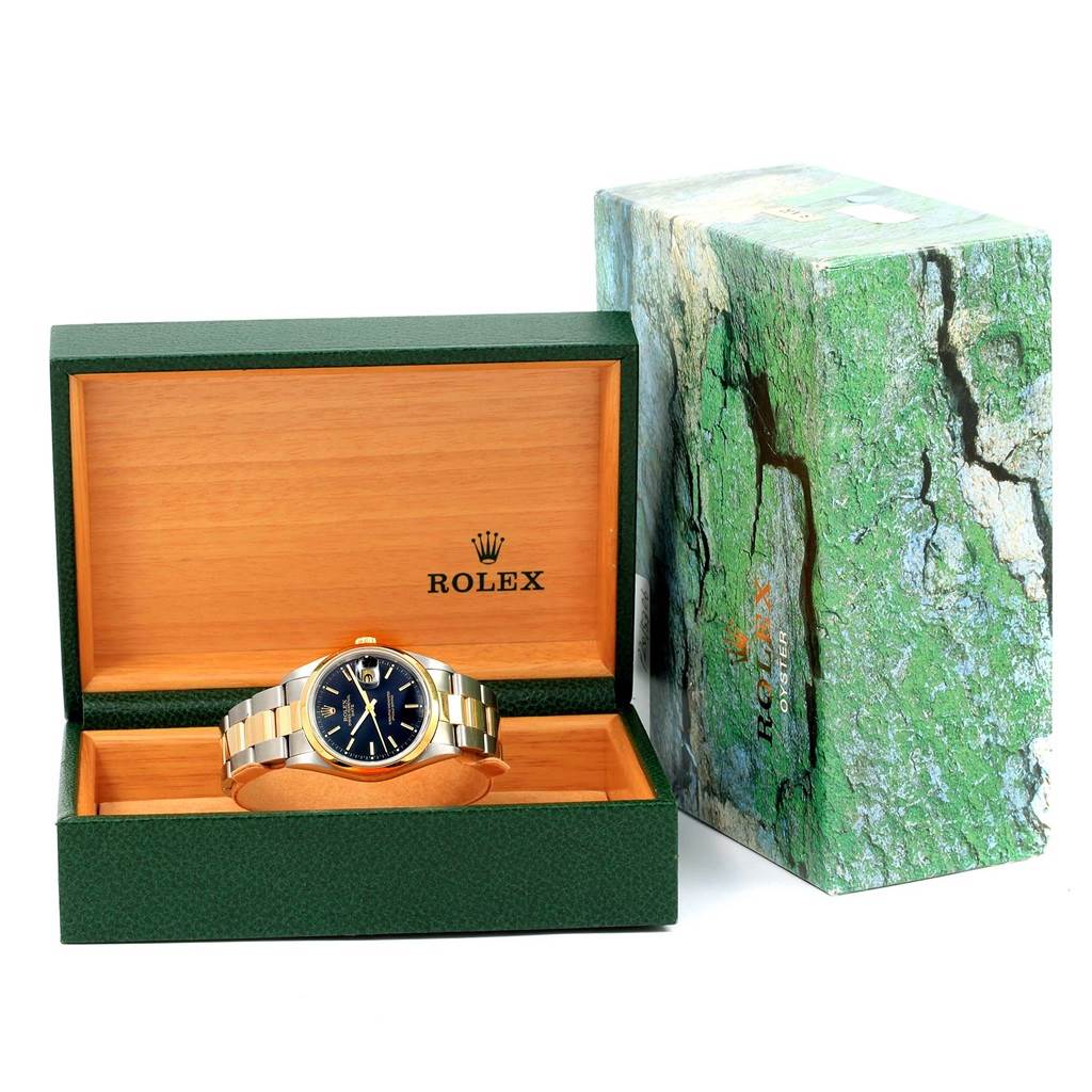 The image shows a Rolex Date 15203 Men's Steel and Gold (two tone) Black Dial 15203 Men's Steel and Gold (two tone) Black Dial watch in its open green and wood box, with its outer green textured box beside it.