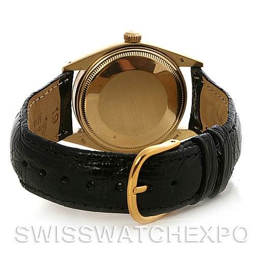 The image shows the back view of a Rolex Date 1503 Men's Yellow Gold Champagne Dial 1503 Men's Yellow Gold Champagne Dial watch with a gold case and black leather strap.