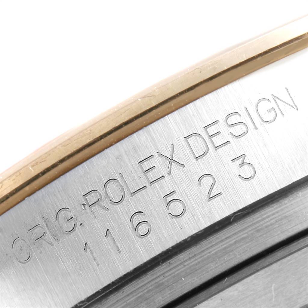 Close-up of the engraved side of a Rolex Daytona 116523 Men's Steel and Gold (two tone) Black Dial 116523 Men's Steel and Gold (two tone) Black Dial watch, showing the model number and "ROLEX DESIGN" inscription.