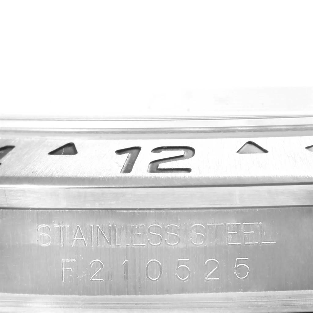 The image shows a close-up of the Rolex Explorer 16570 Men's Stainless Steel Black Dial 16570 Men's Stainless Steel Black Dial's stainless steel bezel and engraved model and serial number.