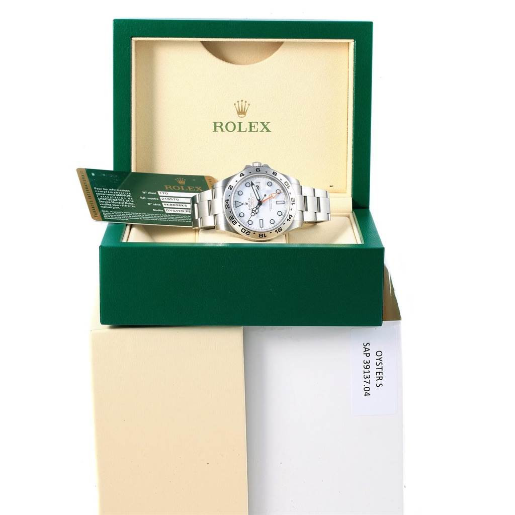 The image shows a Rolex Explorer 216570 Men's Stainless Steel White Dial 216570 Men's Stainless Steel White Dial watch inside an open Rolex box, with the watch and warranty card visible.