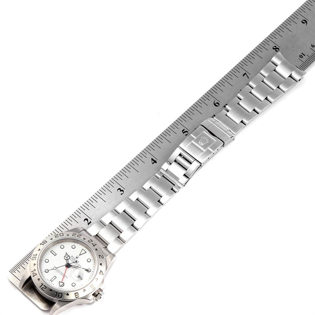 The image shows a top-down view of a Rolex Explorer 16570 Men's Stainless Steel White Dial 16570 Men's Stainless Steel White Dial watch, including its face and entire bracelet, alongside a ruler.