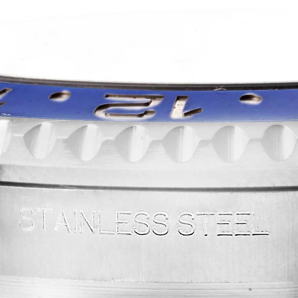 This close-up image of a Rolex GMT-Master 116710 Men's Stainless Steel Black Dial 116710 Men's Stainless Steel Black Dial watch shows part of the bezel and case, highlighting the "STAINLESS STEEL" engraving.