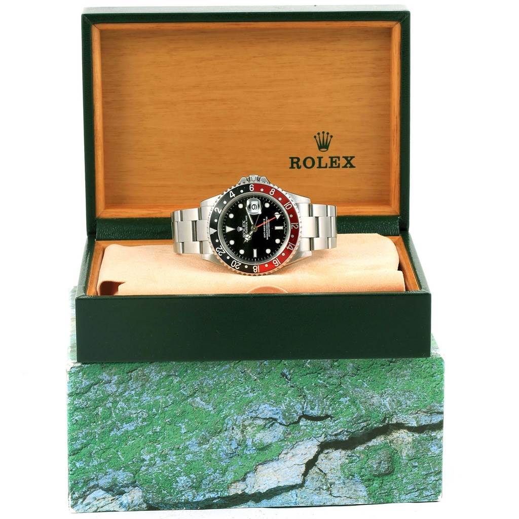 The Rolex GMT-Master 16710 Men's Stainless Steel Black Dial 16710 Men's Stainless Steel Black Dial watch is shown from the front in an open display box, highlighting its face and metal bracelet.