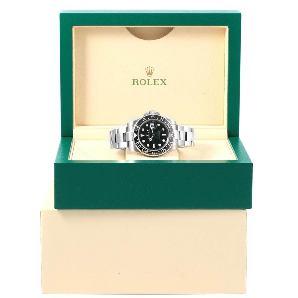 The Rolex GMT-Master 116710 Men's Stainless Steel Black Dial 116710 Men's Stainless Steel Black Dial watch is pictured from the front, displayed in an open green and beige Rolex box.