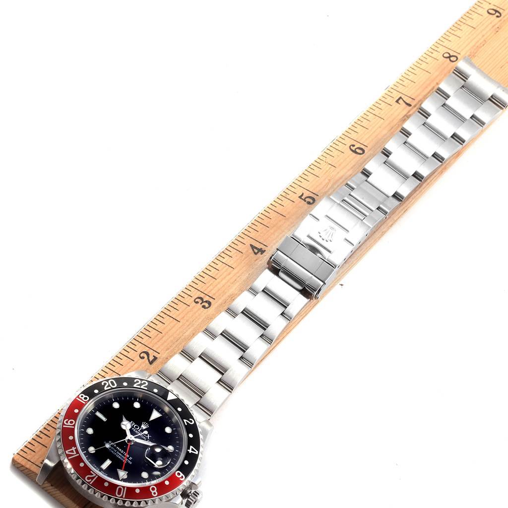 The image shows the Rolex GMT-Master 16710 Men's Stainless Steel Black Dial 16710 Men's Stainless Steel Black Dial watch placed against a ruler, displaying its face, bezel, case, and full bracelet.
