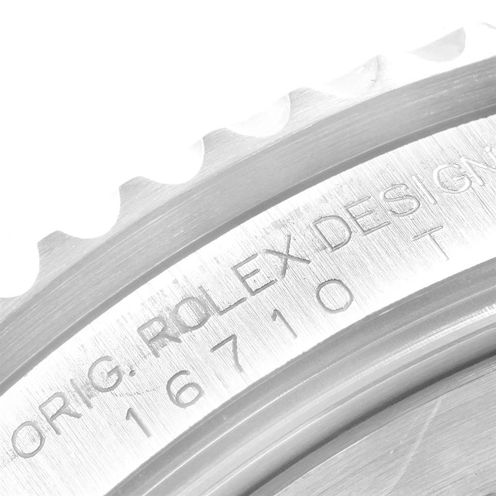 This image shows a close-up of the engraved case back and serrated bezel of a Rolex GMT-Master 16710 Men's Stainless Steel Black Dial 16710 Men's Stainless Steel Black Dial watch.