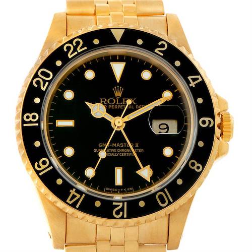 A front view of a Rolex GMT-Master 16718 Men's Yellow Gold Black Dial 16718 Men's Yellow Gold Black Dial II watch, showing its black dial, gold body, and date window at 3 o'clock.