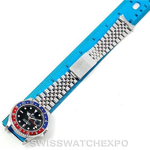 The image shows a top-down view of a Rolex GMT-Master 16710 Men's Stainless Steel Black Dial 16710 Men's Stainless Steel Black Dial watch with a "Pepsi" bezel and jubilee bracelet laid next to a blue ruler.