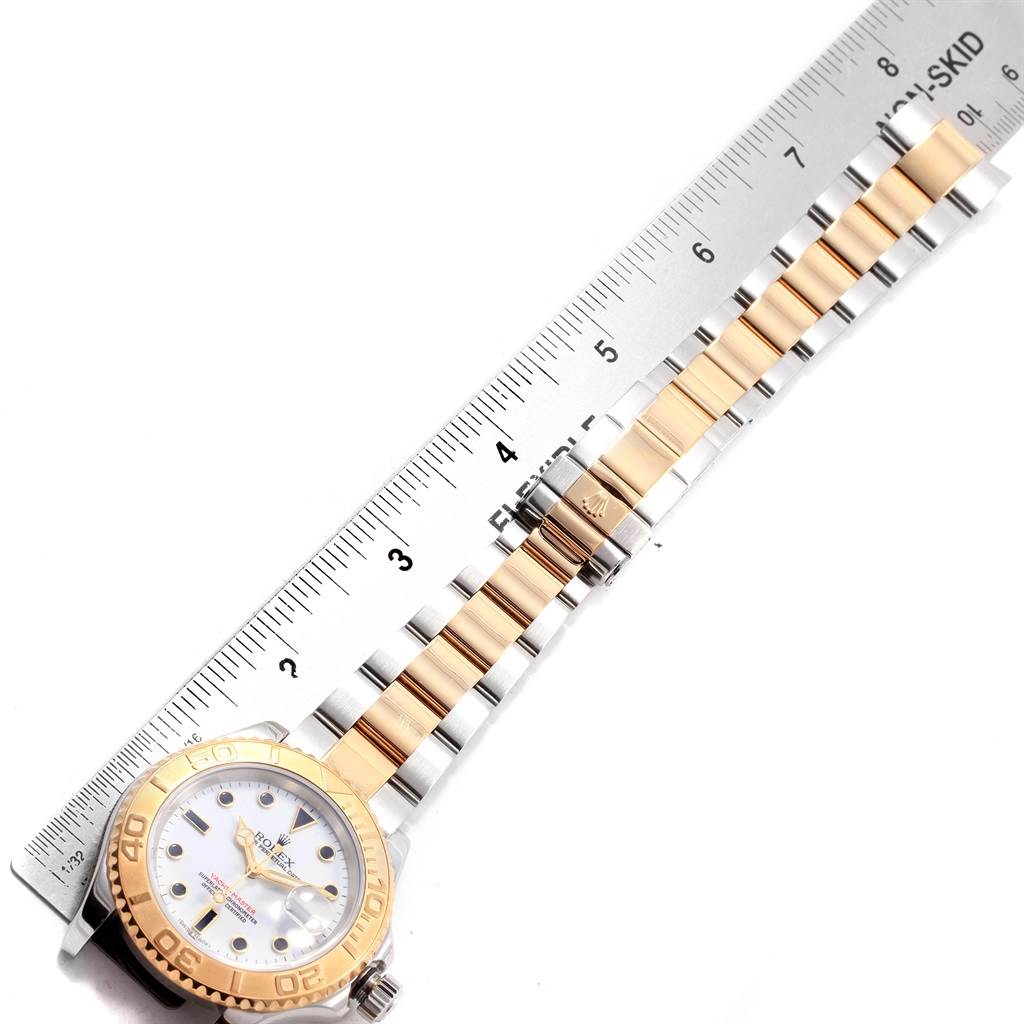 The image shows a Rolex Yacht-Master 16623 Men's Stainless Steel White Dial 16623 Men's Stainless Steel White Dial watch lying flat with its two-tone bracelet extended next to a ruler.