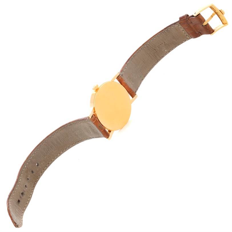 The image shows the back of a Rolex Cellini 5115 Men's Yellow Gold Beige Dial 5115 Men's Yellow Gold Beige Dial watch with its leather strap and gold case.