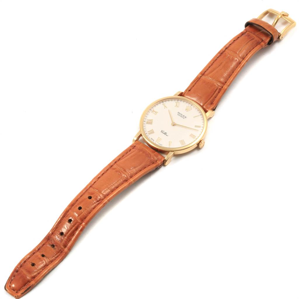 The Rolex Cellini 5112 Men's Yellow Gold Beige Dial 5112 Men's Yellow Gold Beige Dial watch is shown from an overhead angle, displaying its face, leather strap, and buckle.