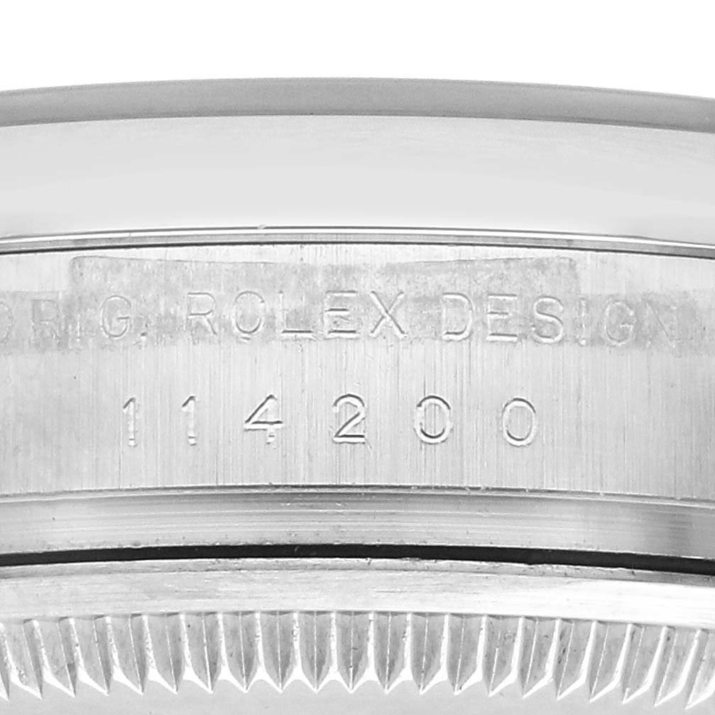 The image shows a close-up of the Rolex Air-King 114200 Men's Stainless Steel White Dial 114200 Men's Stainless Steel White Dial case side, highlighting the model number engraved on the metal.