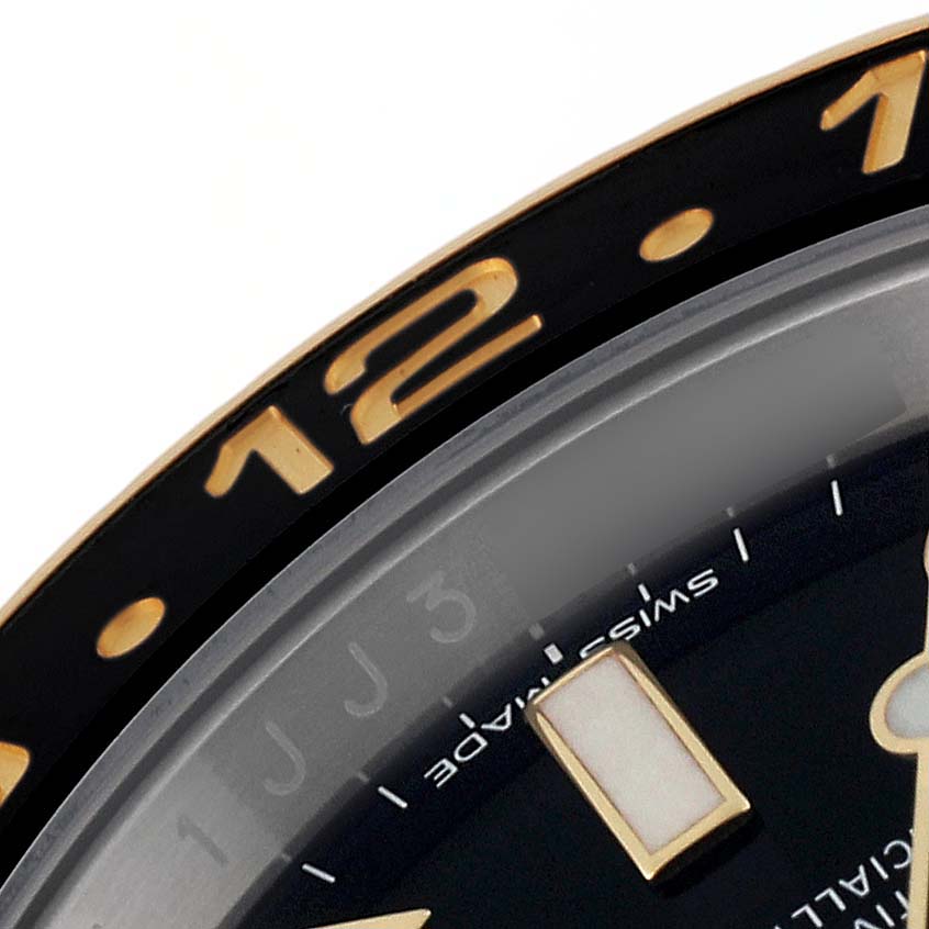 This image shows a close-up of the bezel and part of the dial of a Rolex GMT-Master 116713 Men's Steel and Gold (two tone) Black Dial 116713 Men's Steel and Gold (two tone) Black Dial watch.