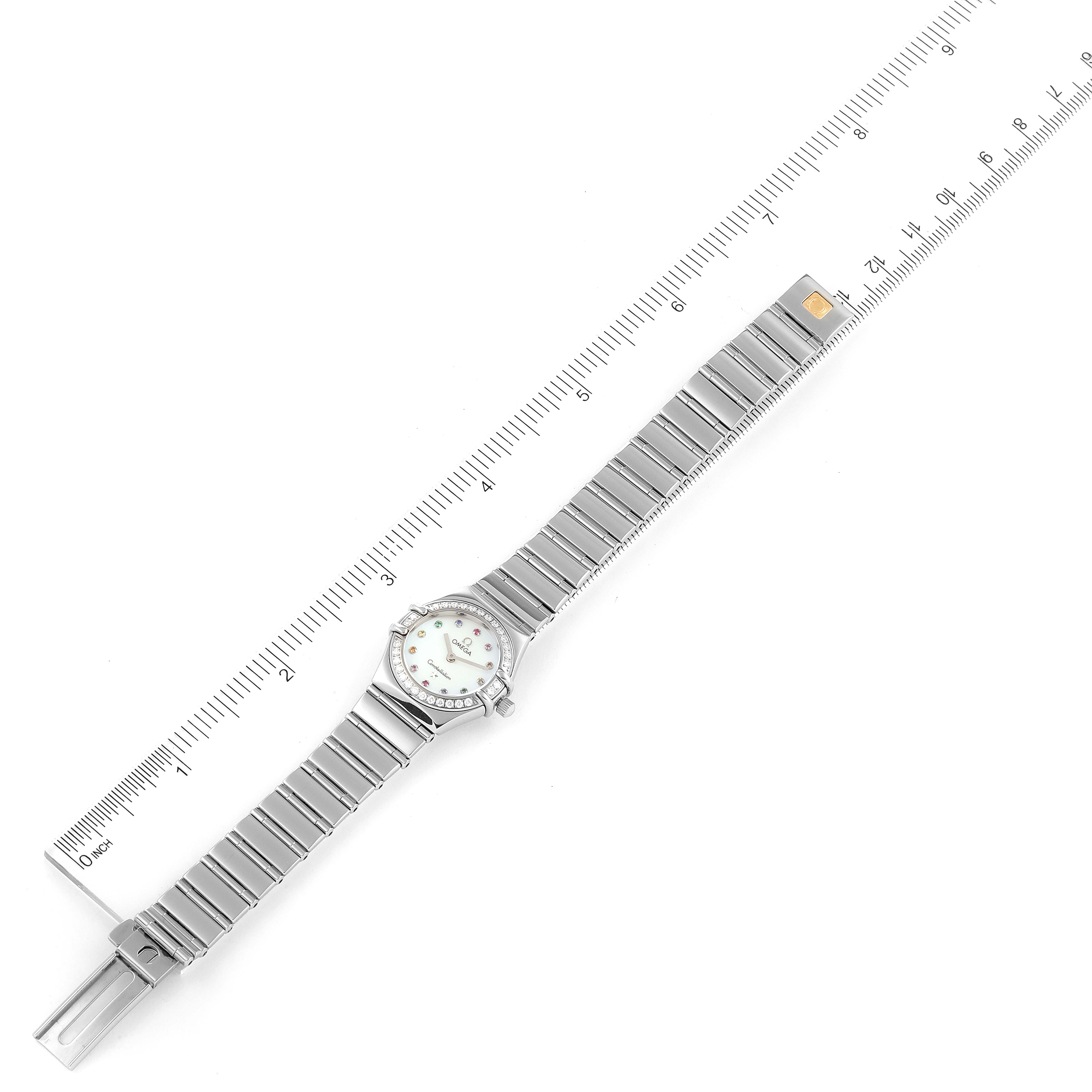 The image shows the Omega 1465.79.00 Women's Stainless Steel Mother of Pearl Dial 1465.79.00 Women's Stainless Steel Mother of Pearl Dial Constellation Iris My Choice Steel Multi Stone Ladies Watch 1465.79.00 laid flat next to a ruler for measurement.