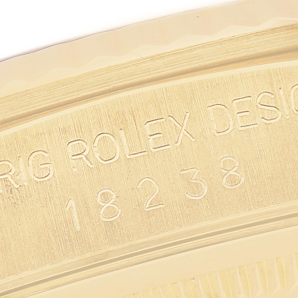 The image shows a close-up of the engraved side of a Rolex President 18238 Men's Yellow Gold Champagne Dial 18238 Men's Yellow Gold Champagne Dial model, featuring its serial number and branding.