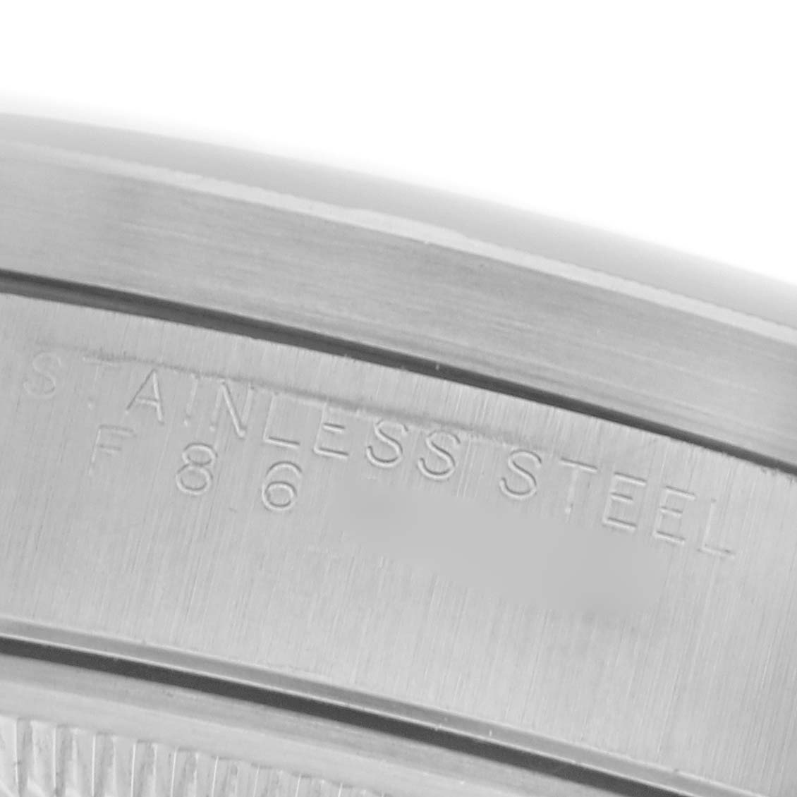The image shows an angled view of the inner bezel of a Rolex Date 15210 Men's Stainless Steel Silver Dial 15210 Men's Stainless Steel Silver Dial watch, highlighting the "STAINLESS STEEL" engraving.