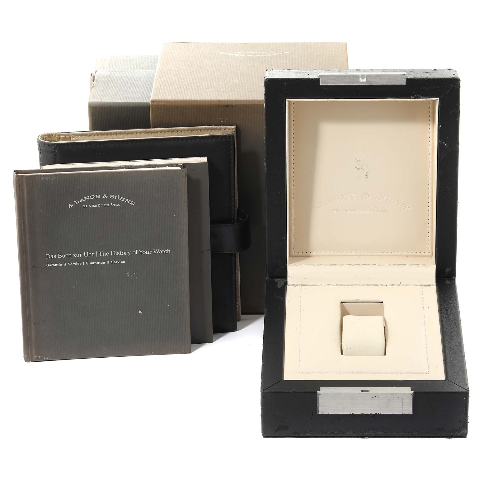 The image shows the packaging and accessories of an A. Lange & Sohne Saxonia watch, including the watch box, manuals, and outer box.