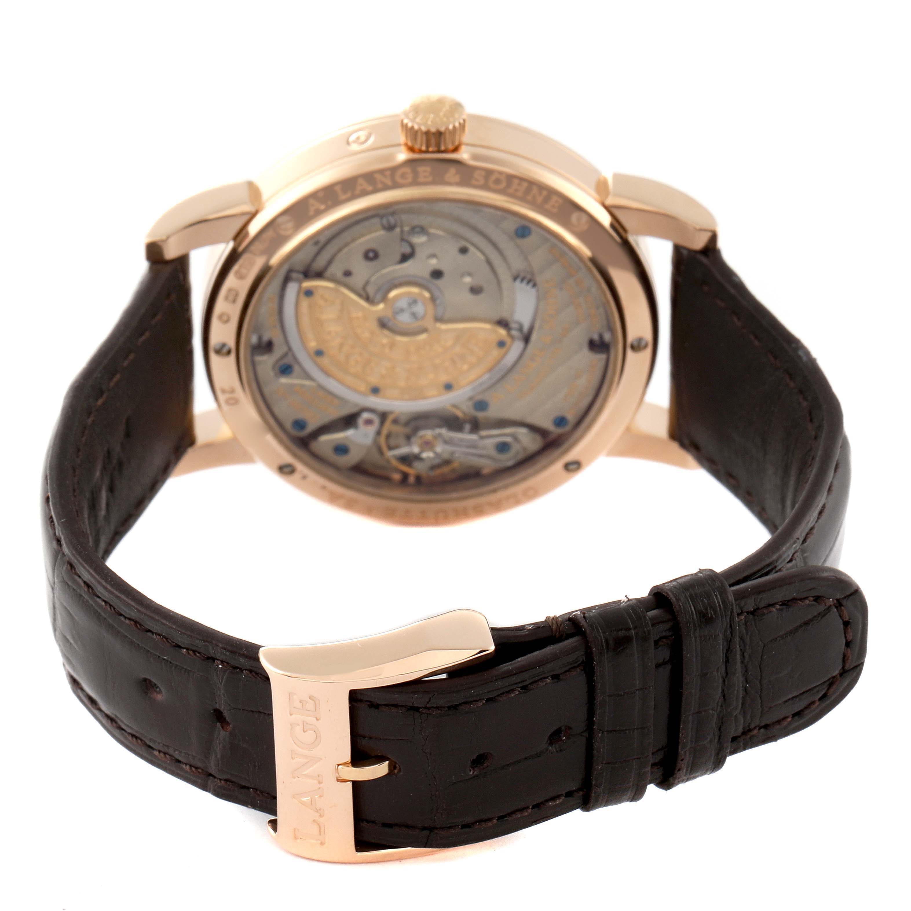 The image shows the back view of a Saxonia model watch by A. Lange & Söhne, highlighting the movement and leather strap.