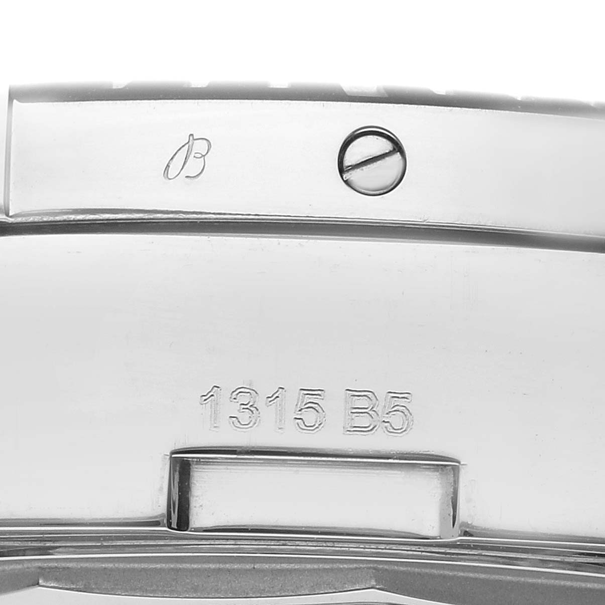 This close-up image shows the Breitling logo, a screw, and the serial number on the casing of a Colt model Breitling watch.