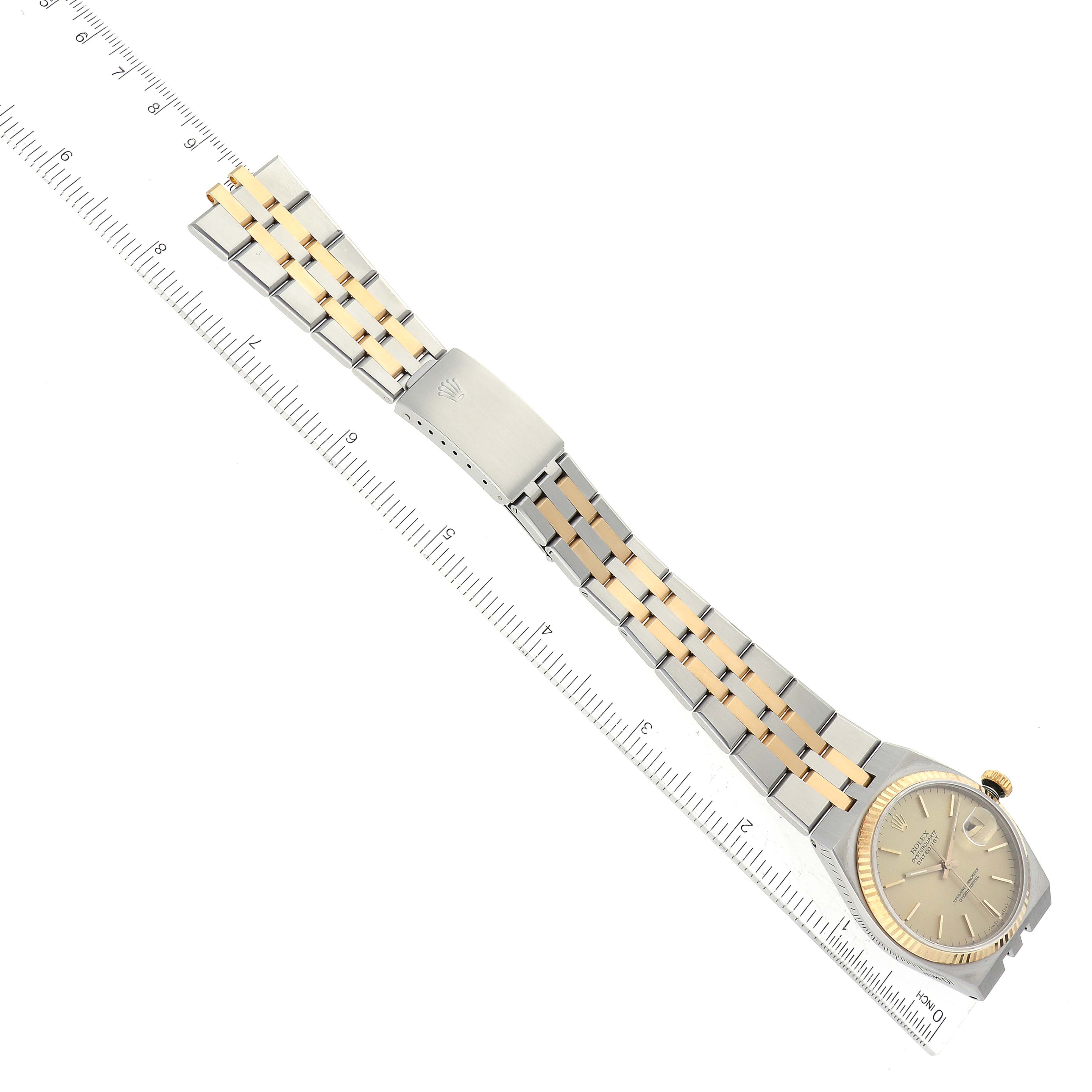 The image shows a Rolex Oysterquartz 17013 Men's Steel and Gold (two tone) Champagne Dial 17013 Men's Steel and Gold (two tone) Champagne Dial watch laying flat with a ruler beneath it, displaying the watch face, bezel, crown, and full bracelet.