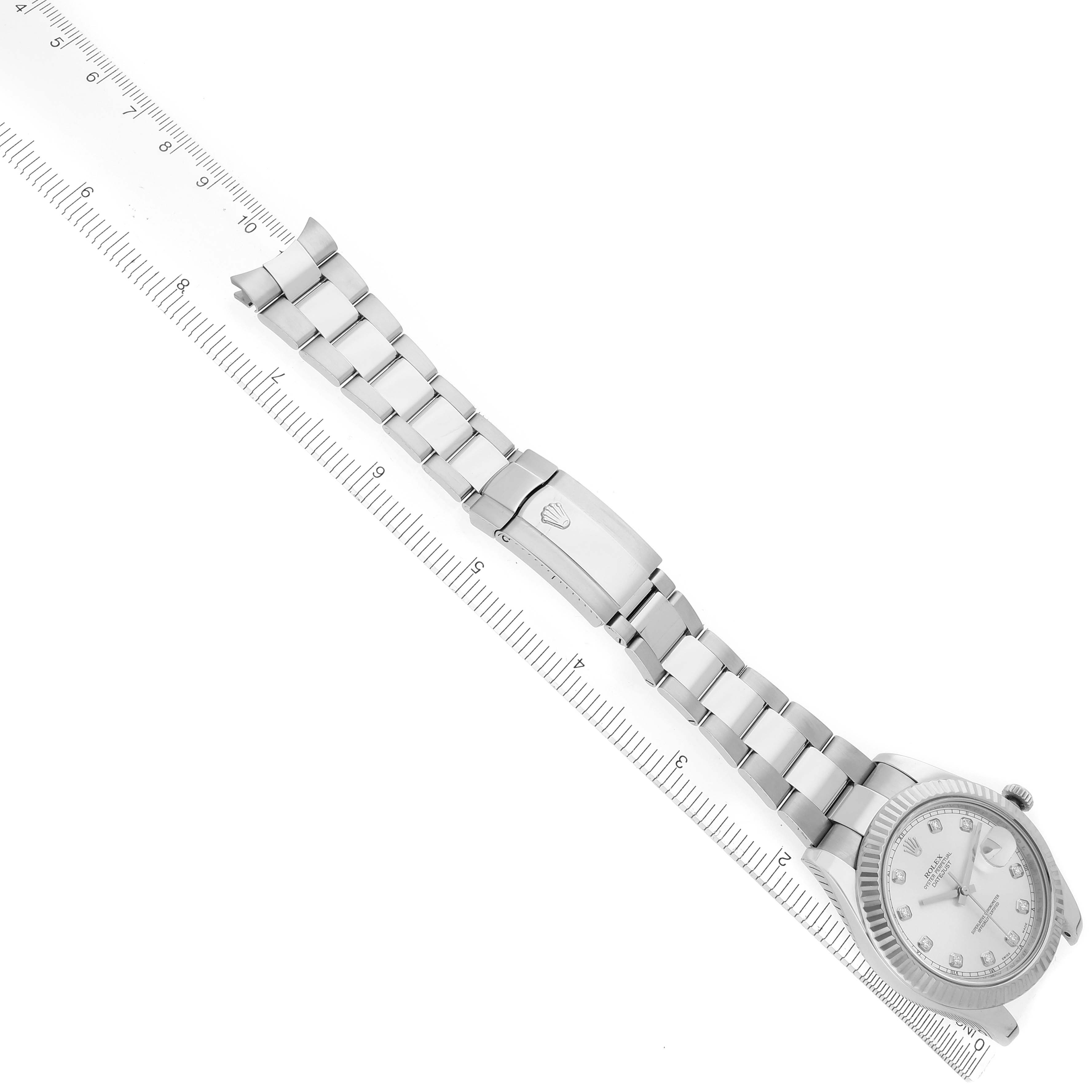 The Rolex Datejust 41 116334 Men's Stainless Steel Silver Dial 116334 Men's Stainless Steel Silver Dial is shown at an angle, highlighting the face, bezel, and full bracelet with a clasp alongside a ruler.