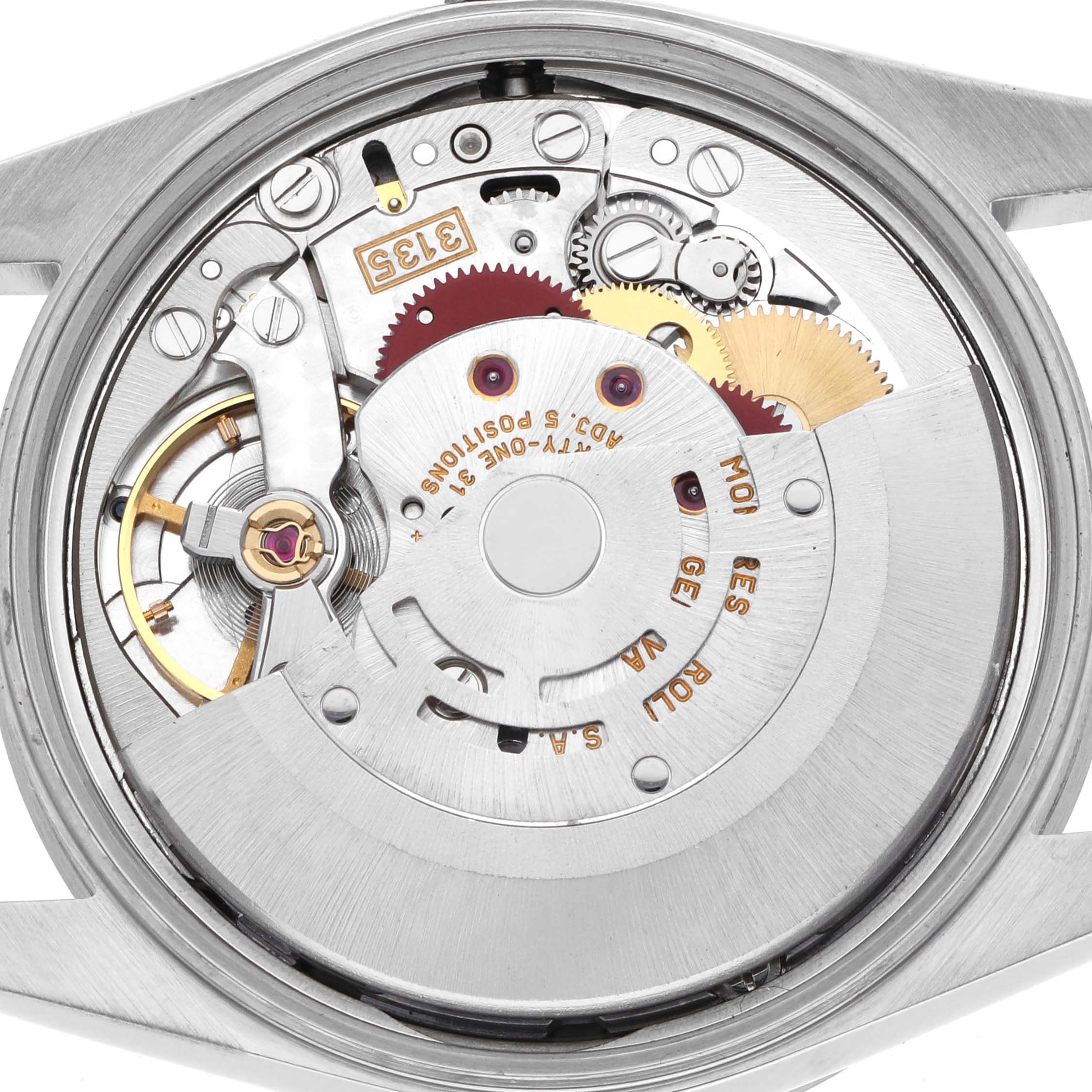 The image shows the movement of a Rolex Date 15210 Men's Stainless Steel Blue Dial 15210 Men's Stainless Steel Blue Dial watch from the back, highlighting gears and components in a polished case.