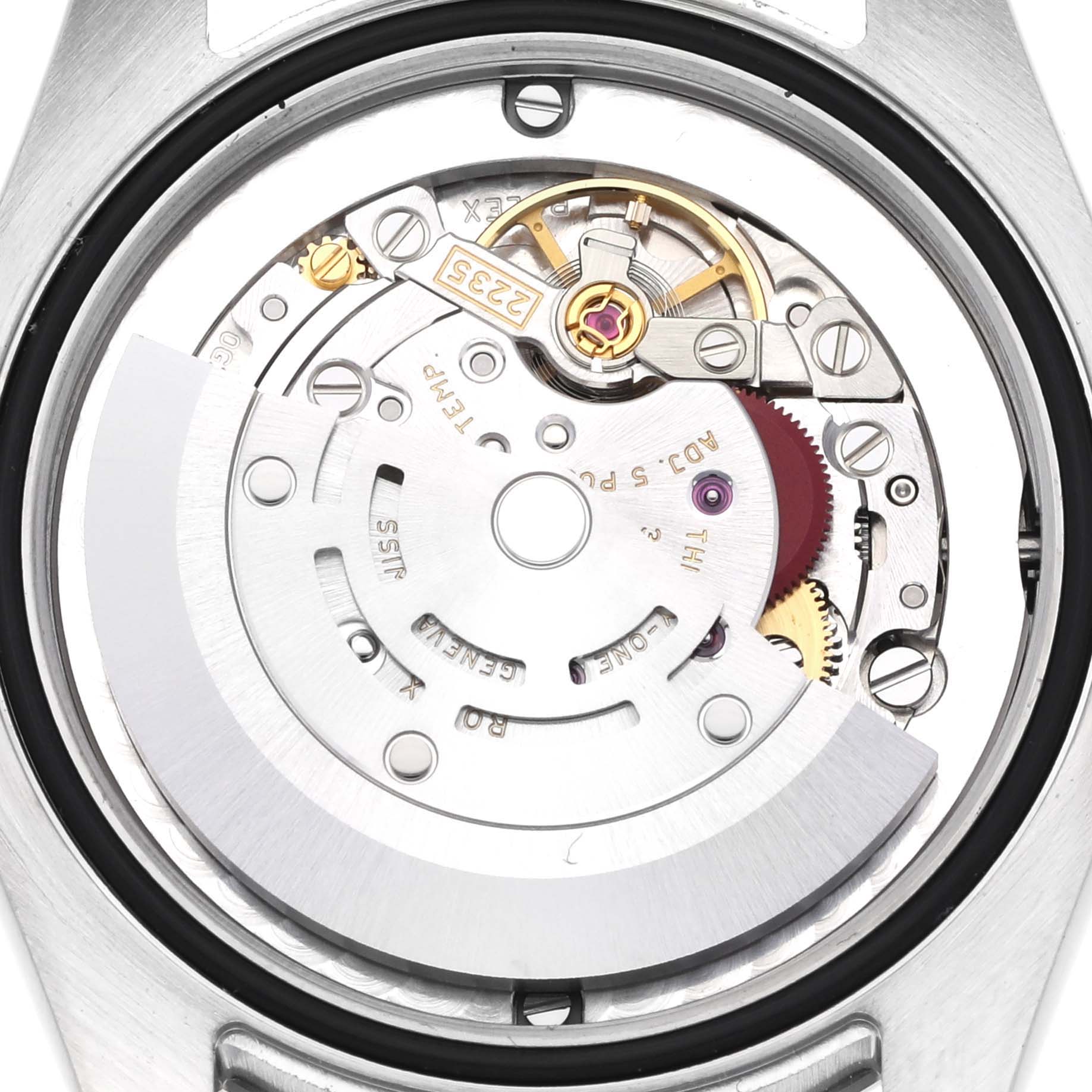 The image shows the back view of a Rolex Datejust, highlighting the intricate movement and rotor mechanism.