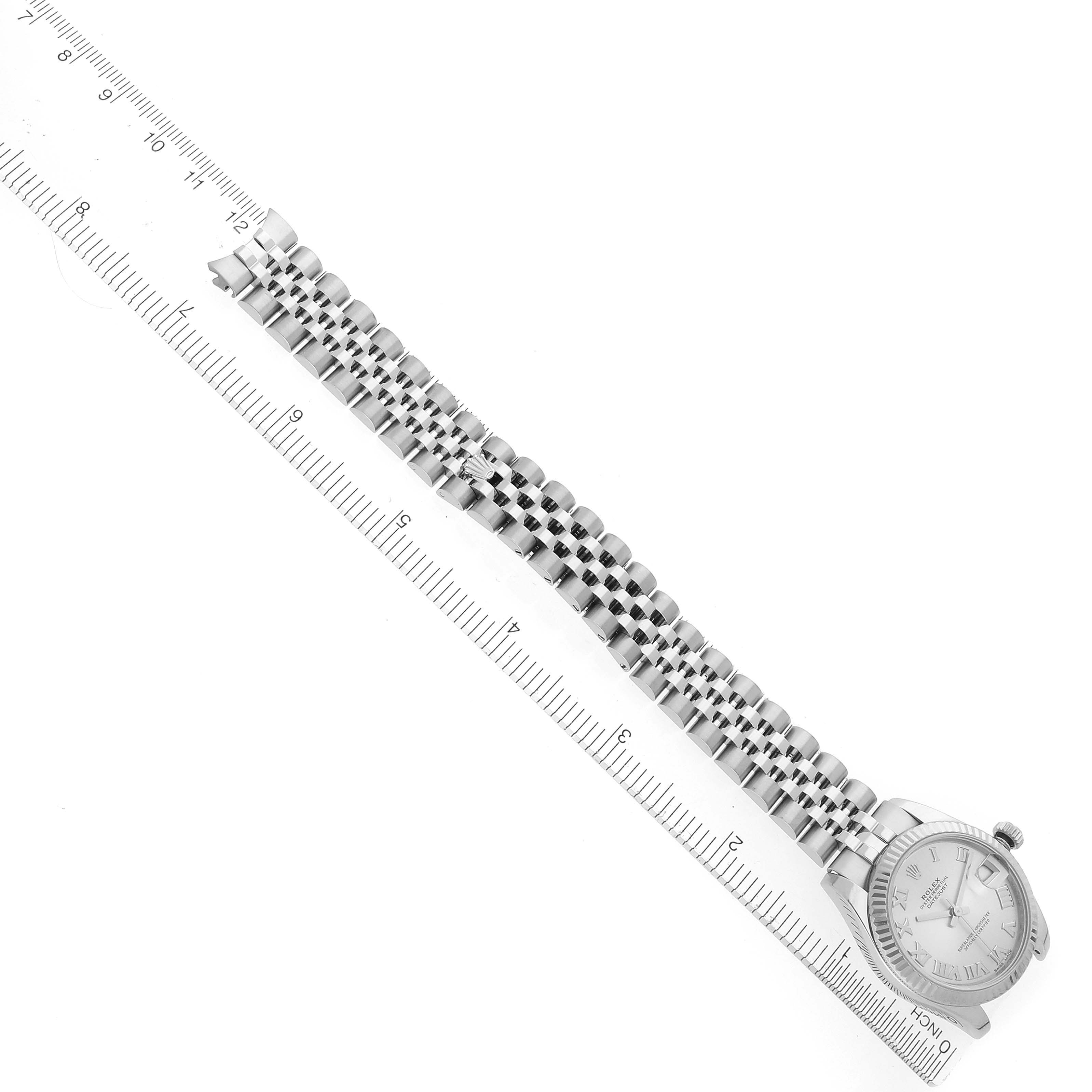 The image shows a Rolex Datejust watch diagonally with a jubilee bracelet beside a ruler for scale.