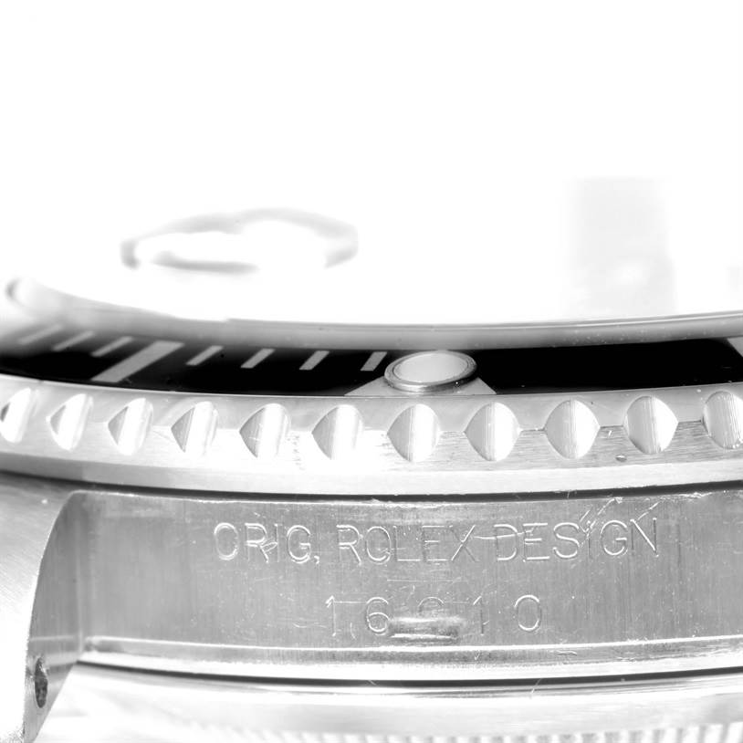 The image shows a close-up of the side of a Rolex Submariner 16610 Men's Stainless Steel Black Dial 16610 Men's Stainless Steel Black Dial, highlighting the bezel and engraved model details.