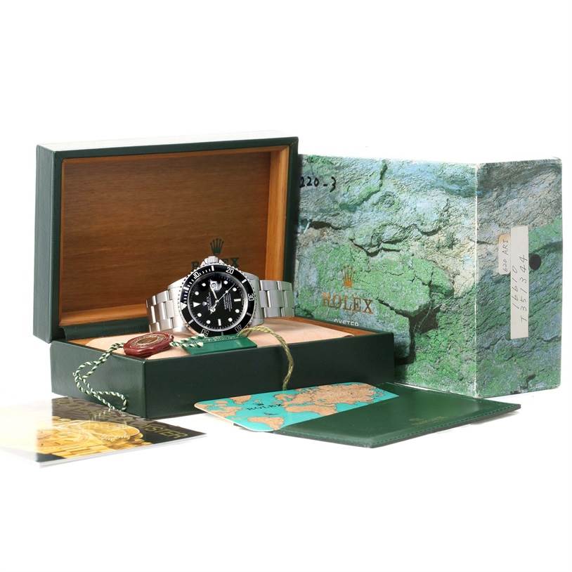 The image shows a Rolex Submariner 16610 Men's Stainless Steel Black Dial 16610 Men's Stainless Steel Black Dial watch displayed in its open box, alongside its outer box and accompanying documents and tags.