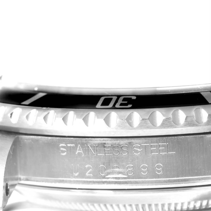 Close-up of the Rolex Submariner 16610 Men's Stainless Steel Black Dial 16610 Men's Stainless Steel Black Dial's bezel and case showing engraved details.