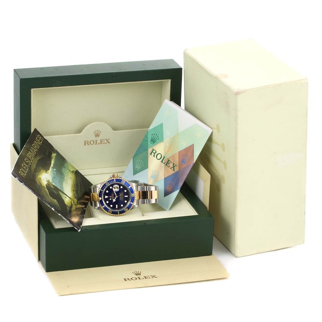 The image shows a Rolex Submariner 16613 Men's Steel and Gold (two tone) Blue Dial 16613 Men's Steel and Gold (two tone) Blue Dial watch with its box, manuals, and original packaging from a frontal angle.
