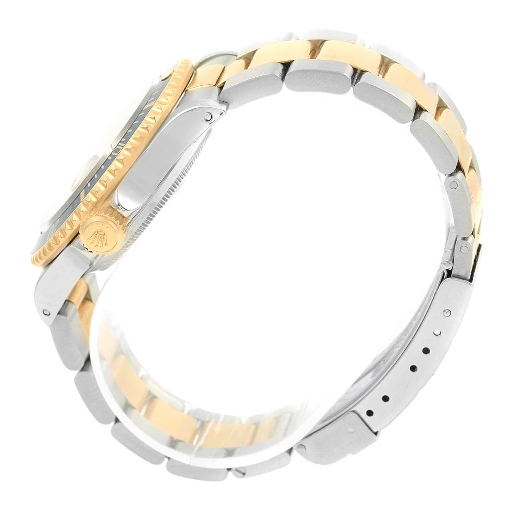 The image shows a side view of a Rolex Submariner 16613 Men's Steel and Gold (two tone) Champagne Dial 16613 Men's Steel and Gold (two tone) Champagne Dial watch focusing on its gold and silver bracelet and the crown.