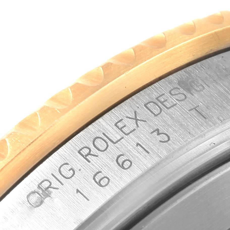 This close-up image shows the engraved model number and bezel edge of a Rolex Submariner 16613 Men's Steel and Gold (two tone) Grey Dial 16613 Men's Steel and Gold (two tone) Grey Dial watch.