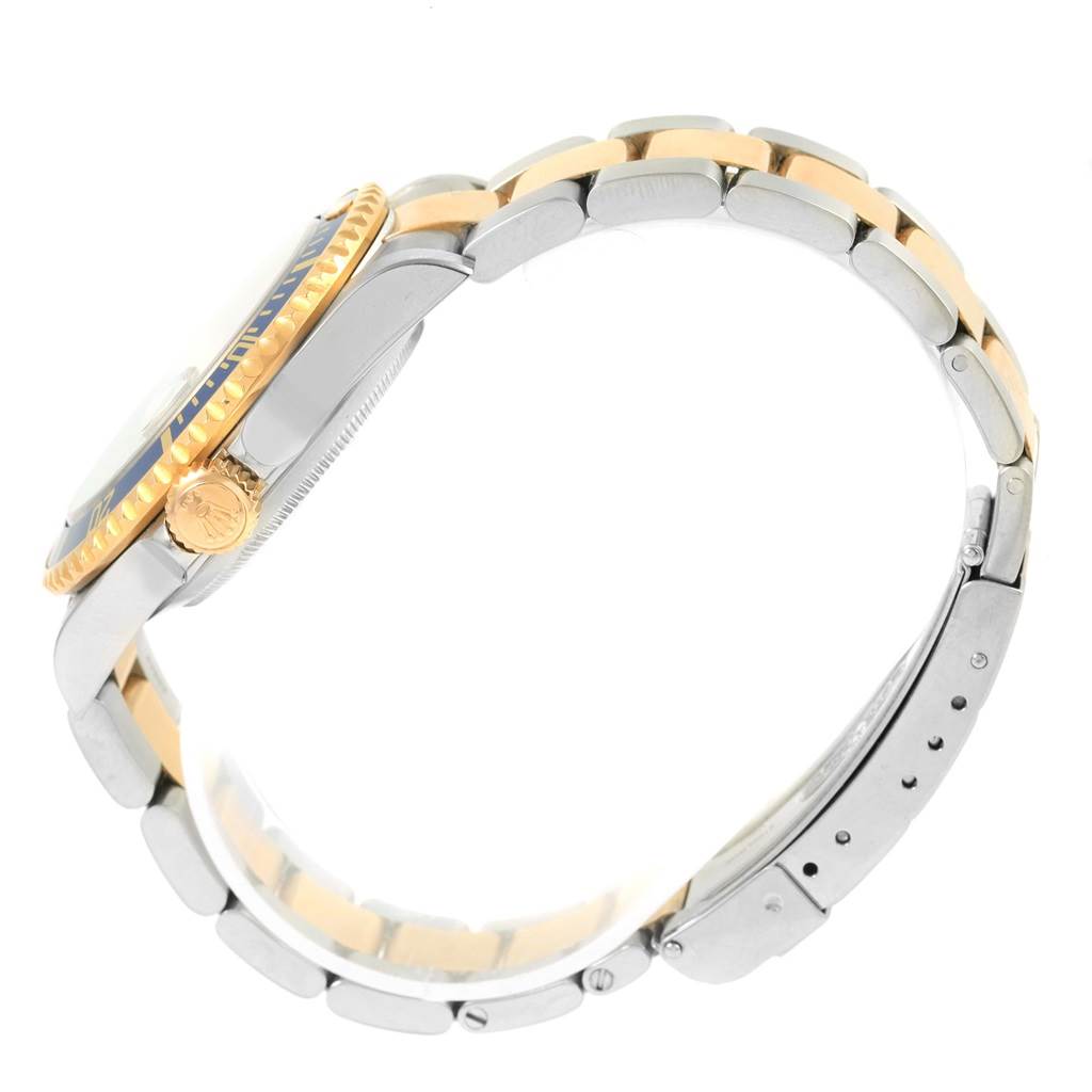 The Rolex Submariner 16613 Men's Steel and Gold (two tone) Grey Dial 16613 Men's Steel and Gold (two tone) Grey Dial model is shown from a side angle, highlighting the bezel, crown, and two-tone bracelet.