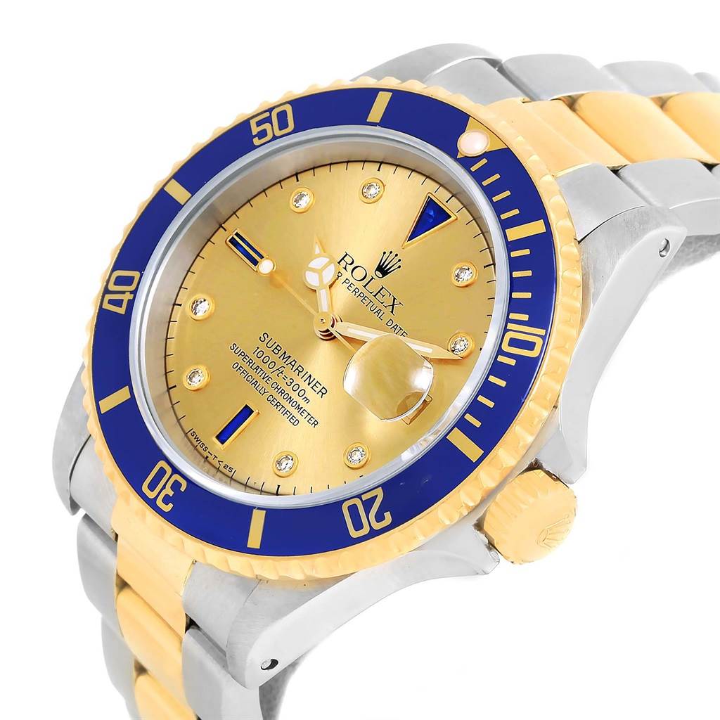 The image shows a Rolex Submariner 16613 Men's Steel and Gold (two tone) Champagne Dial 16613 Men's Steel and Gold (two tone) Champagne Dial watch at an angle displaying its gold and blue bezel, dial, crown, and bracelet.