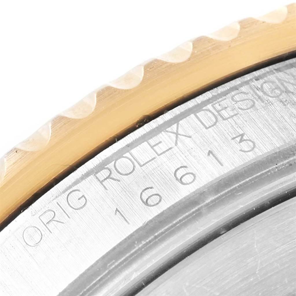 The image shows a close-up angle of the bezel and case edge of a Rolex Submariner 16613 Men's Steel and Gold (two tone) Blue Dial 16613 Men's Steel and Gold (two tone) Blue Dial watch, displaying the model number and part of the design engraving.